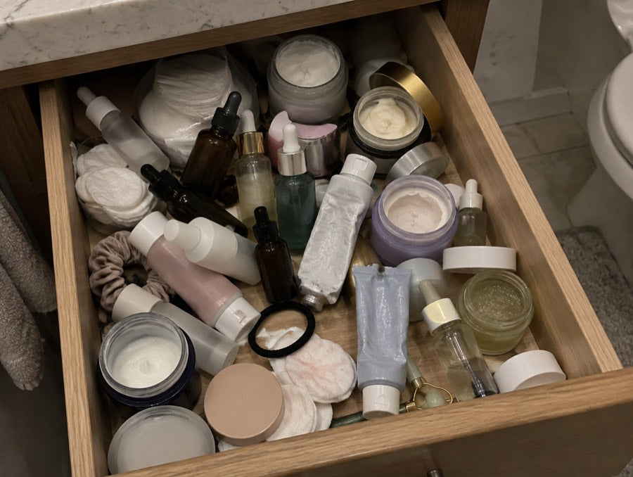A crowded drawer of half-used anti-aging creams and serums